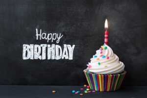 Single Cupcake With One Lit Candle With The Words Happy Birthday